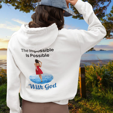 Gildan unisex zip-up hoodie with “Impossible Woman” design featuring a woman walking on water and uplifting message, Christian apparel made from soft cotton-poly fleece, ideal for cooler weather and faith-forward style, 2nd woman in white hoodie